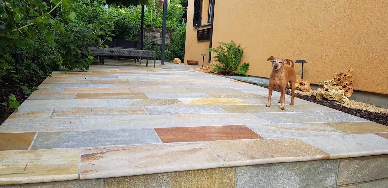 Terrazza esterna in quarzite brasiliana con lastre rettangolari dalle sfumature chiare e dorate